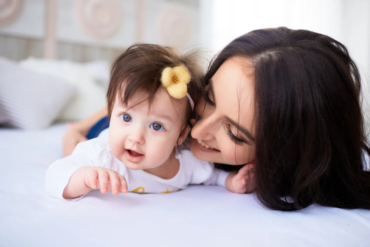 A mother smiling beside her baby